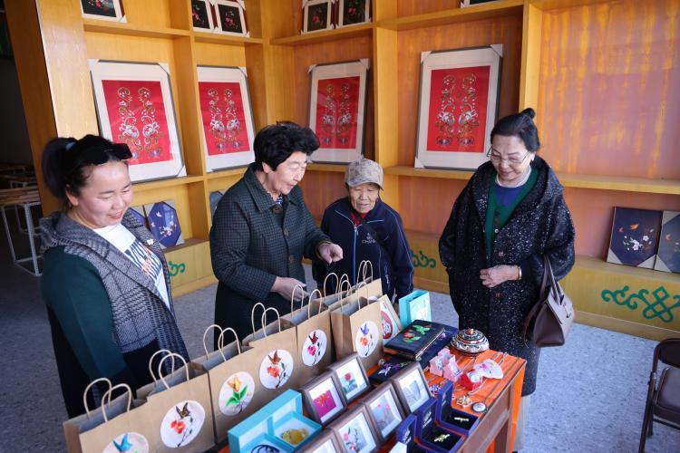 白晶莹在非遗展示点，向景区游客讲解蒙古族刺绣手工艺品许城玮 摄.jpg